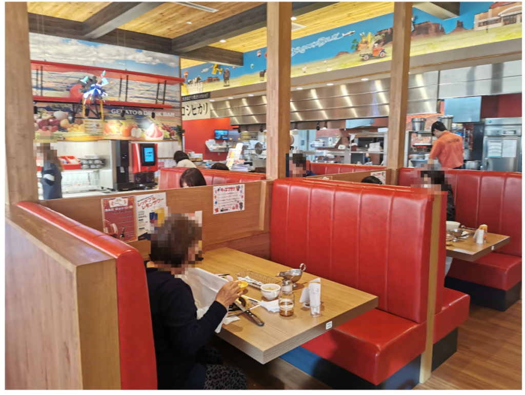 赤いレザーのボックス席が並ぶ客席。ペンダントライトとウォールアートで程よく落ち着いた空気感。